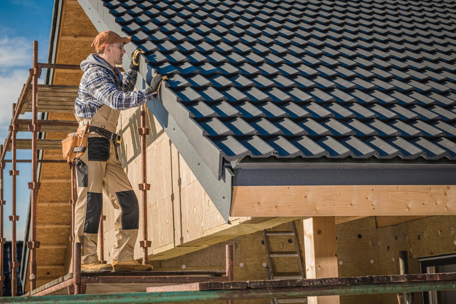 Roof inspector examining edge flashing and tile alignment on a completed residential roof repair